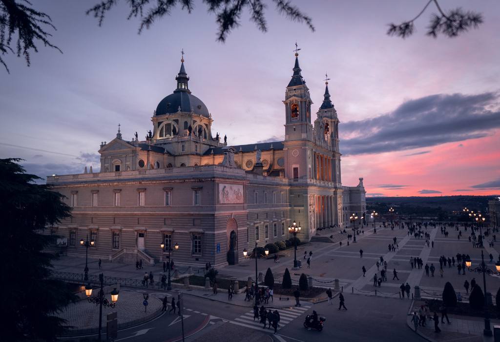 Spanish cathedral at sunset with pink and purple skies.