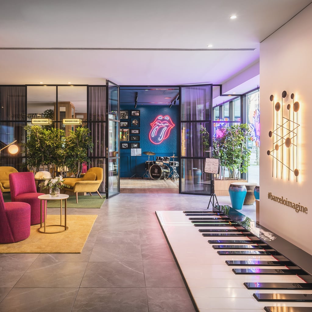 Lobby of Barcelo Imagine Hotel in Madrid with piano keys on the floor and neon Rolling Stones logo