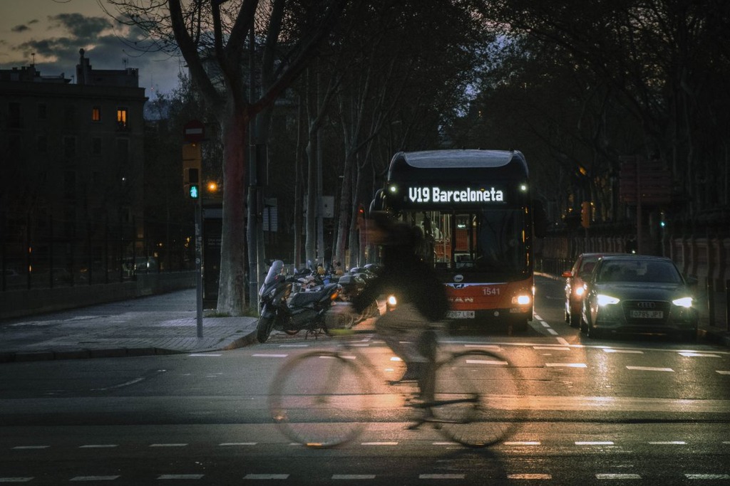 Man riding bicycle across the road at night in Barcelona 