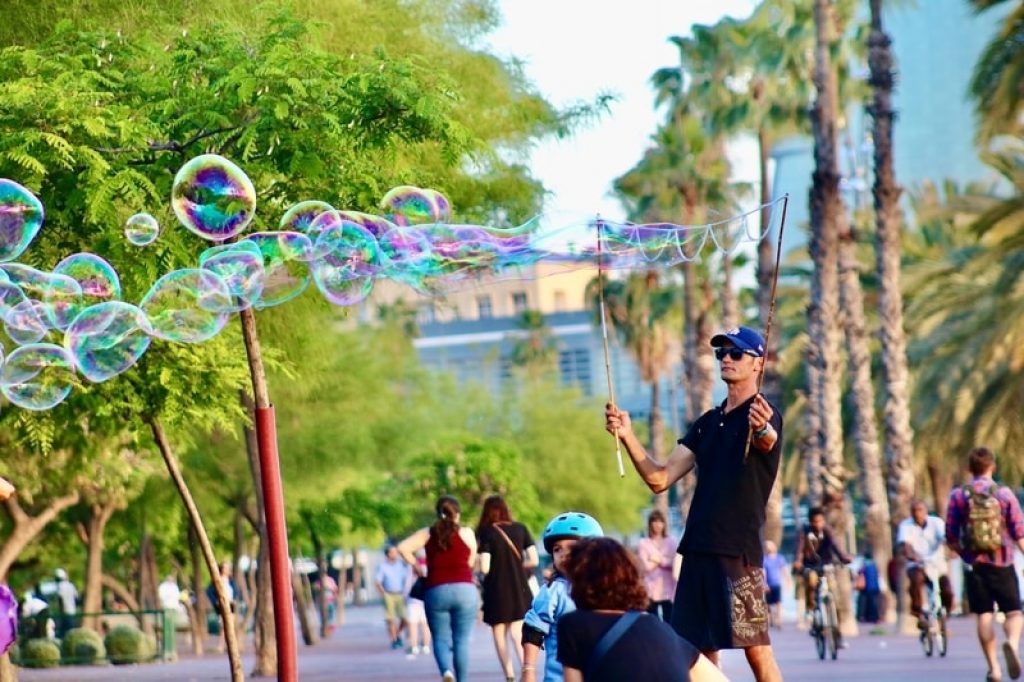 man-playing-with-bubbles-in-park-barcelona
