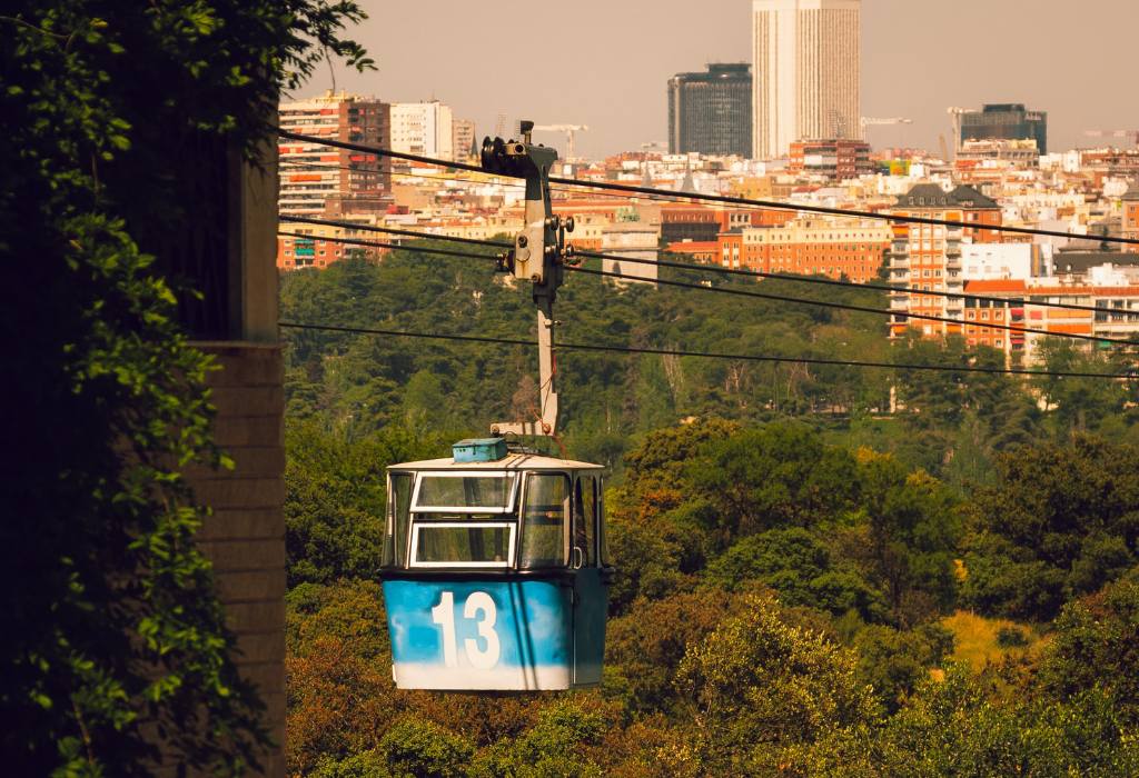 Blue cable car going over the city.