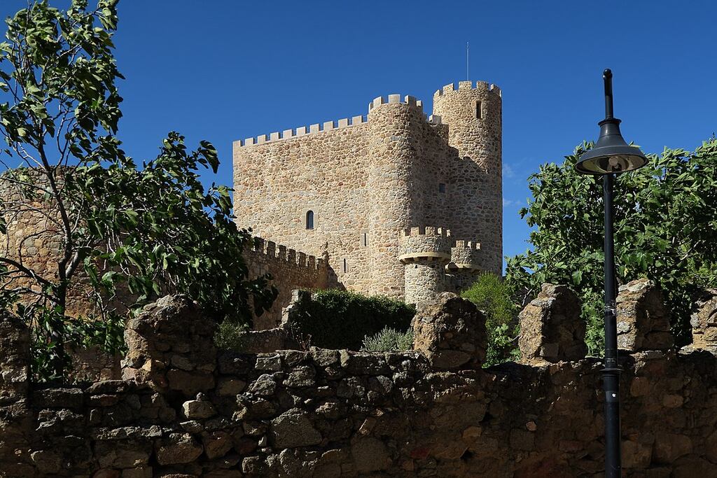 A view of one of the towers of the Castillo de la Coracera through the trees in San Martin de Valdeiglesias Madrid, Spain