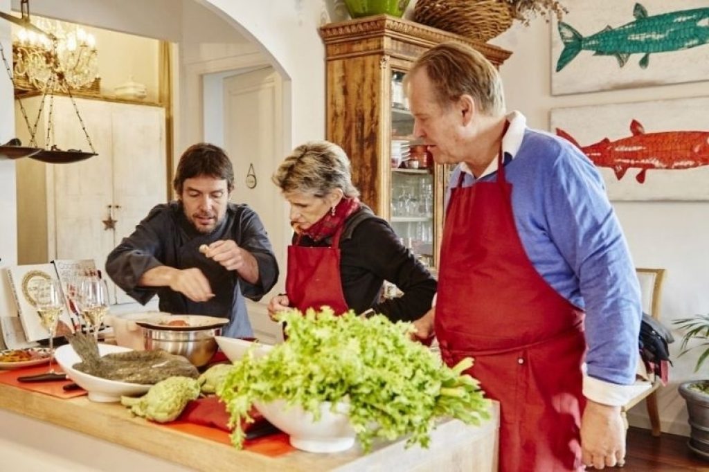 Chef assisting couple to cook