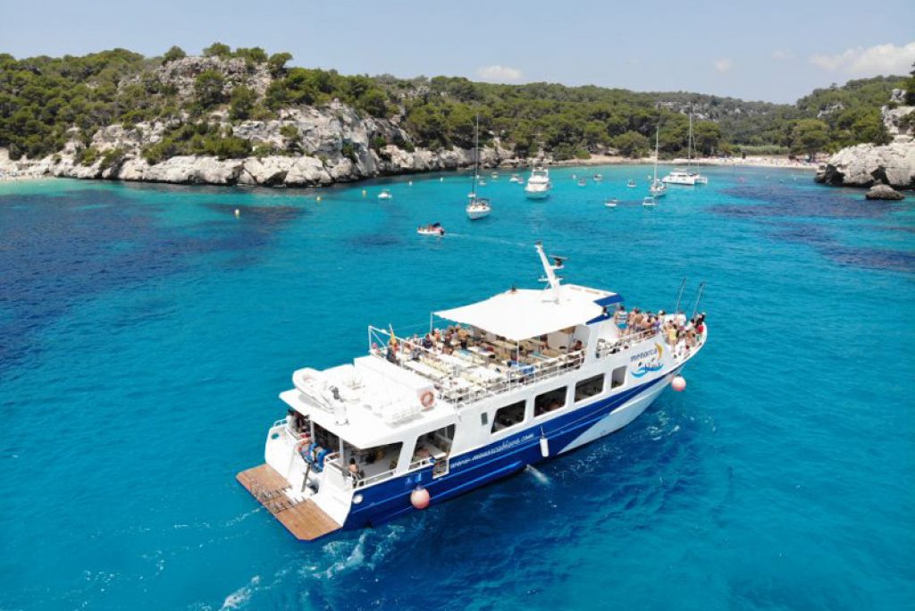 cruise boat in blue water menorca bay