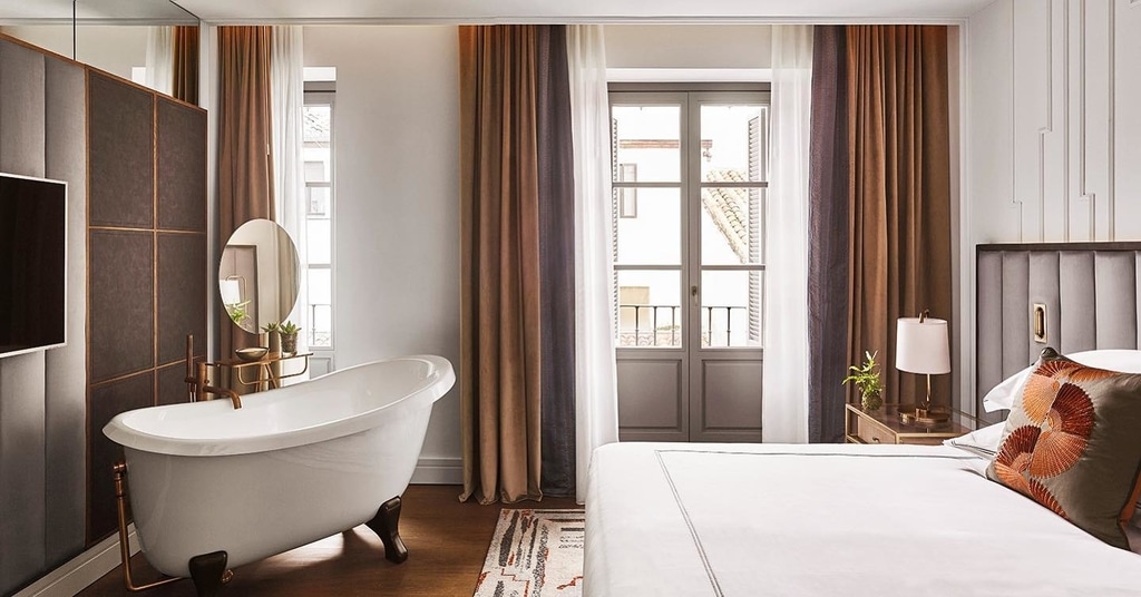 Bathtub and bedroom in Gran Hotel Ingles room, Madrid
