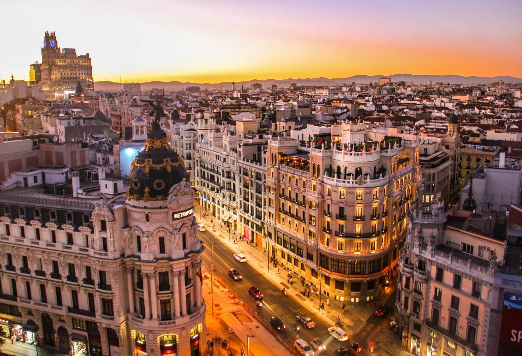 Birds eye view of buildings and street at sunset.