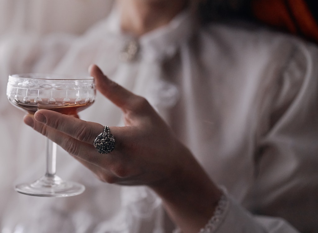 Lady holding a glass of an alcoholic drink.