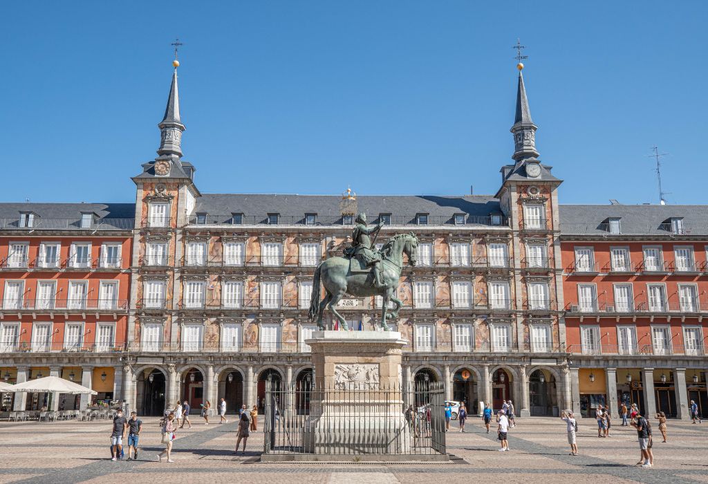 Large public square in Madrid with statue of a man on a horse.