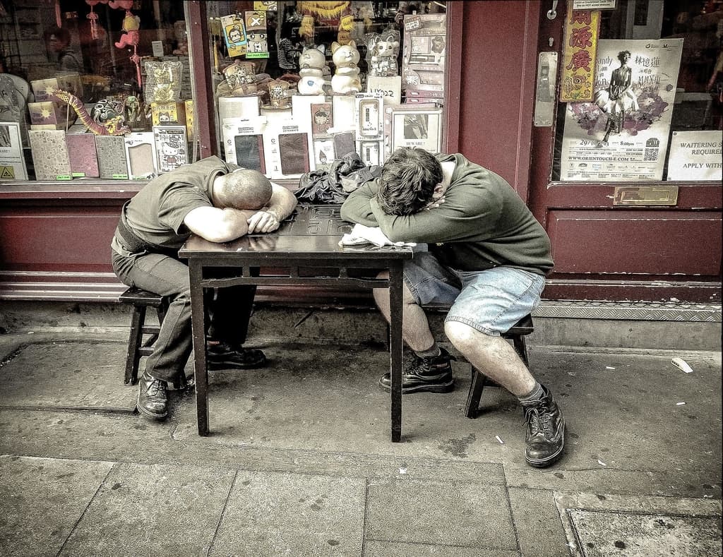 Two men asleep on a cafe table