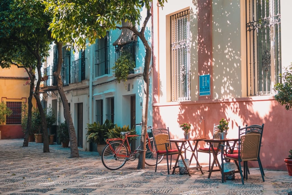 A street in Spain showing an empty table and a bike