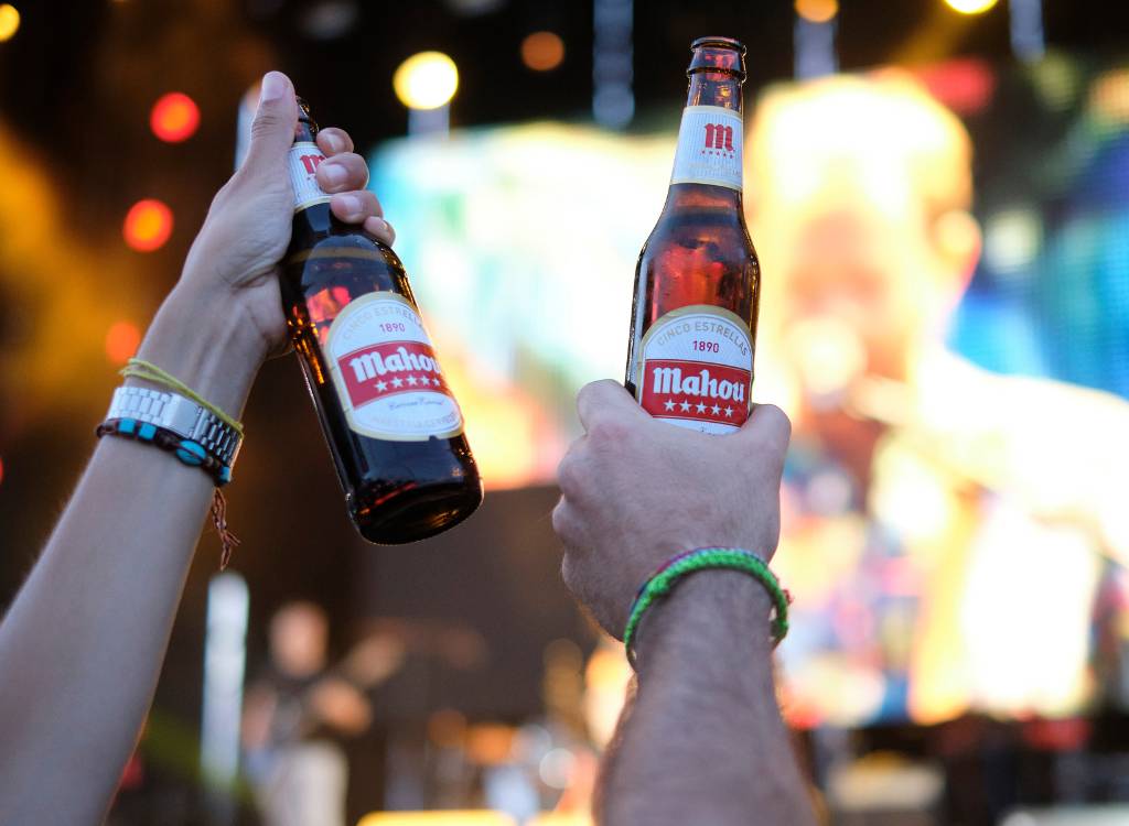 Close up image of people at Vibra Mahou Fest holding bottles.
