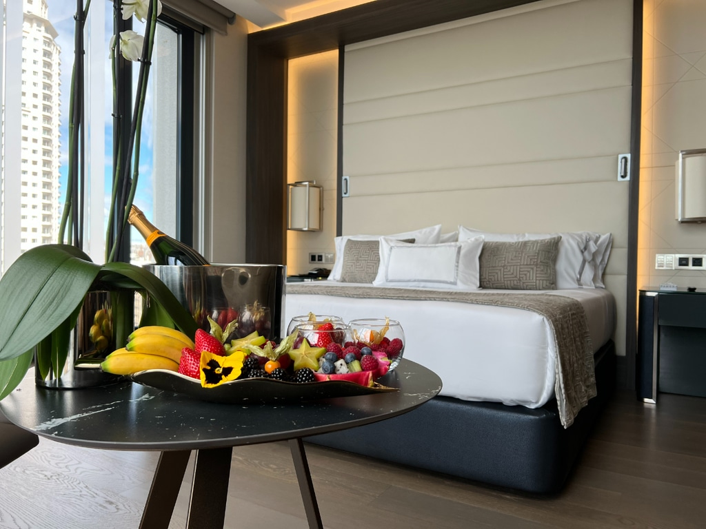 Room in VP Plaza Espana Design Hotel with white linen and flowers on table